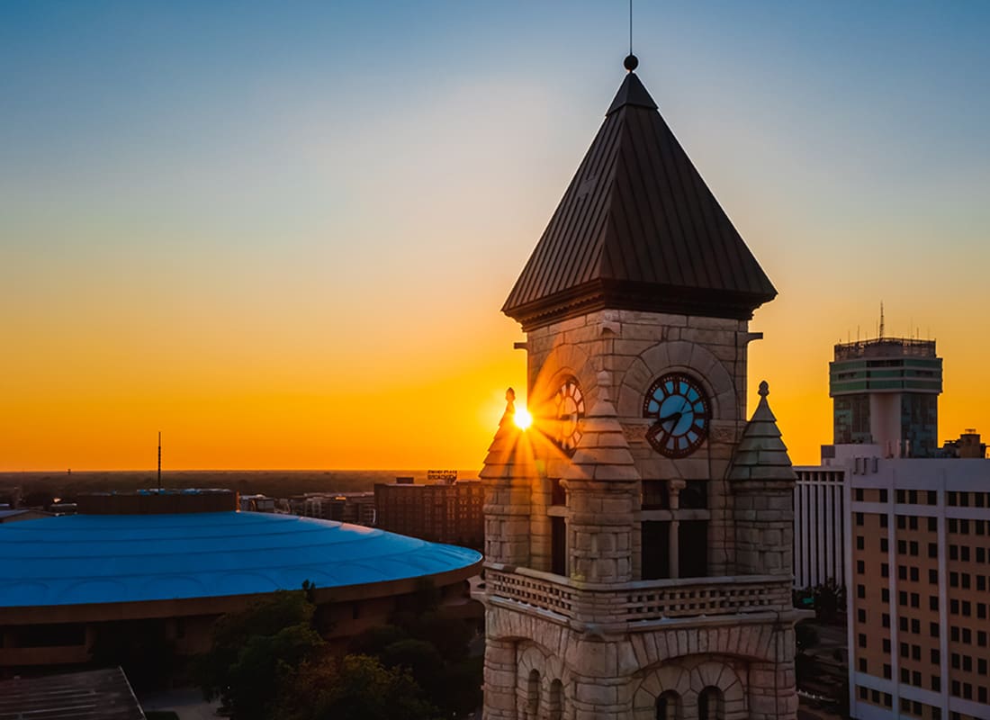 Read Our Reviews - Closeup View of a Clock Tower in Downtown Wichita Kansas Against a Colorful Sunset Sky